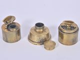 three antique brass objects on a white surface with a white background