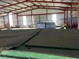 a large warehouse with a lot of green bins in it