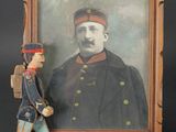 une vieille photo représentant un homme en uniforme militaire à côté d'un soldat de plomb
