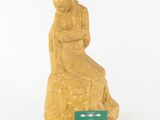 statue of a woman sitting on a rock with a green card in front of her