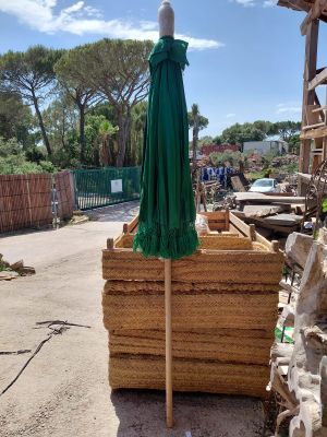 a green umbrella sitting on top of a pile of wood