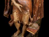 statue of a man holding a book and a bird on a rock