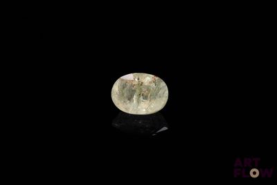 a close up of a green diamond on a black surface