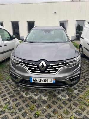 a grey car parked in front of a building next to other cars