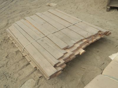 un tas de bois posé par terre, dans le sable