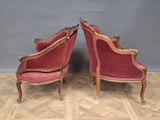 two red chairs sitting on top of a wooden floor next to each other