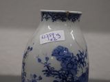 a blue and white vase with a tag on it