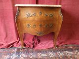une commode en bois avec un plateau en marbre, posée sur un tapis