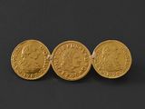 three gold sovereigns on a black background