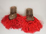 two pairs of shoes with red fringes on them on a white surface