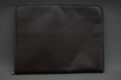 une image représentant un étui en cuir marron pour iPad sur fond noir