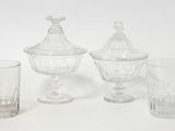 three glasses and a vase on a white surface