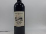 la bouteille de vin rouge est posée sur une surface blanche