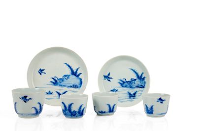 plusieurs assiettes et tasses en porcelaine bleue et blanche posées sur une surface blanche