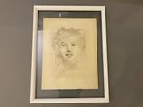 drawing of a woman ' s face in a white frame on a wall