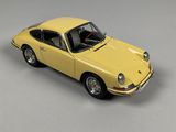 yellow model of a car on a white surface with a gray background