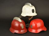 pair of red and white fire helmets on a black background
