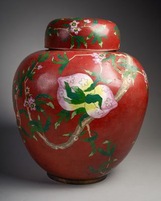 un vase rouge sur lequel est peinte une fleur