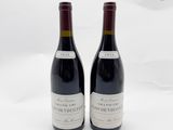 deux bouteilles de vin rouge posées l'une à côté de l'autre sur une surface blanche