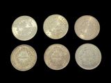 six different types of silver coins on a black background