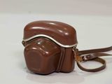 a chocolate camera bag with a strap on it