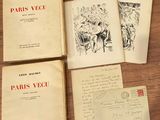 plusieurs vieux livres posés sur une table, sur lesquels figure un dessin à la plume et à l'encre