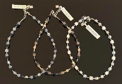deux paires de bracelets en perles noires et blanches, munis d'étiquettes