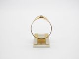 an image of a gold ring sitting on top of a marble block