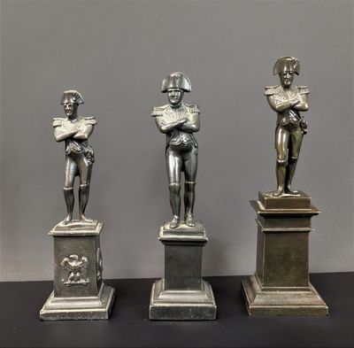 trois statues représentant un homme tenant un livre et une femme en train de lire un livre