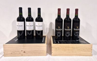Plusieurs bouteilles de vin sont posées dans une caisse en bois sur une table