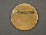 a small gold pin with a red star on it