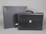 a black briefcase sitting next to a box on a table