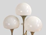 three white glass and brass table lamps on a gray background