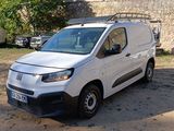 une camionnette blanche garée devant un mur de pierre