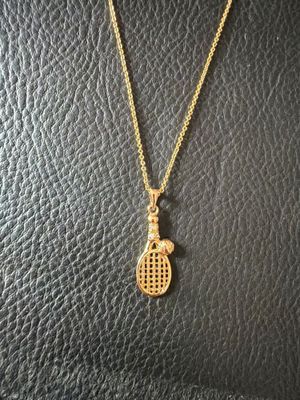 a gold tennis racket necklace on a mannequin mannequin mannequin mannequin mannequin mannequin mannequin mannequin