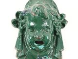 a green statue of a woman with a surprised face