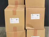 des cartons empilés sur une palette devant un mur noir