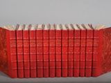 a group of red books sitting on top of each other on a table
