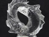 une sculpture en verre représentant un poisson sur fond noir