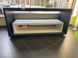 une étagère noire et blanche ornée d'un ruban rouge