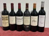 six bottles of wine are lined up on a table