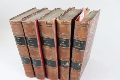 plusieurs vieux livres sont empilés sur une surface blanche