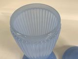 two blue glass vases sitting on a white table