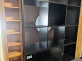 a room with a desk, bookshelf, and a chair in it