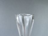 a clear glass vase with a red handle on a table