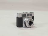 a black and silver camera on a white surface