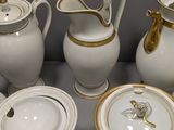 a lot of white and gold china on a table