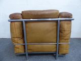 a brown leather chair with a metal frame on the floor