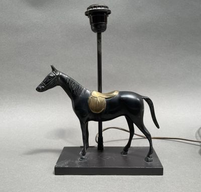 statue of a horse with a saddle on a base with a lamp on it