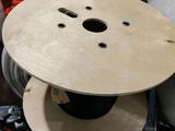 une bobine en bois posée dans une boîte remplie de fils